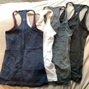 Four Lululemon tanks, grey, white, black and navy blue.